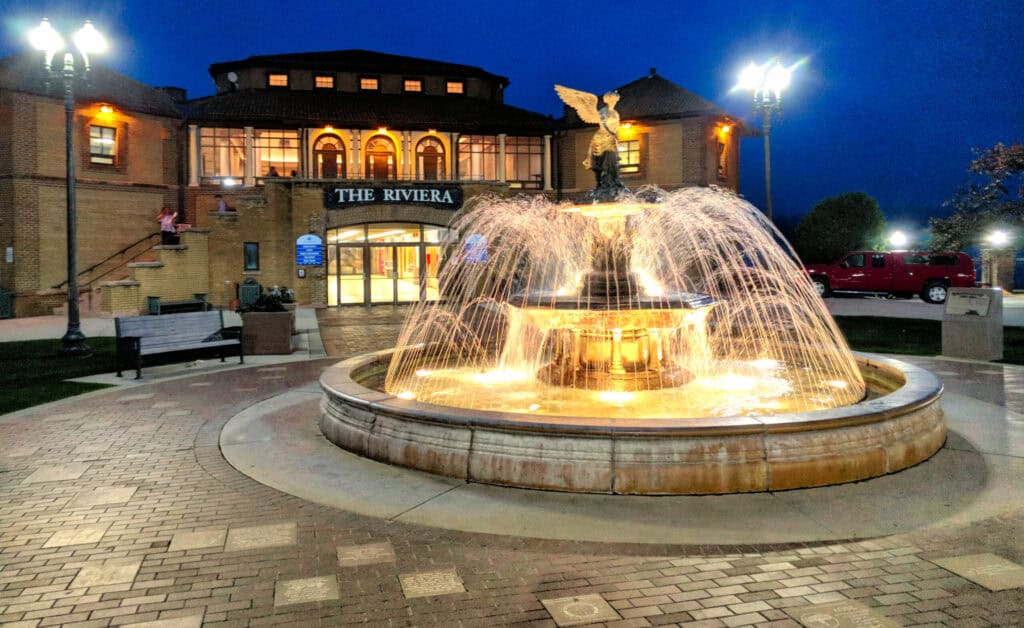 Night view of The Riviera fountain at Lake Geneva with illuminated water feature.