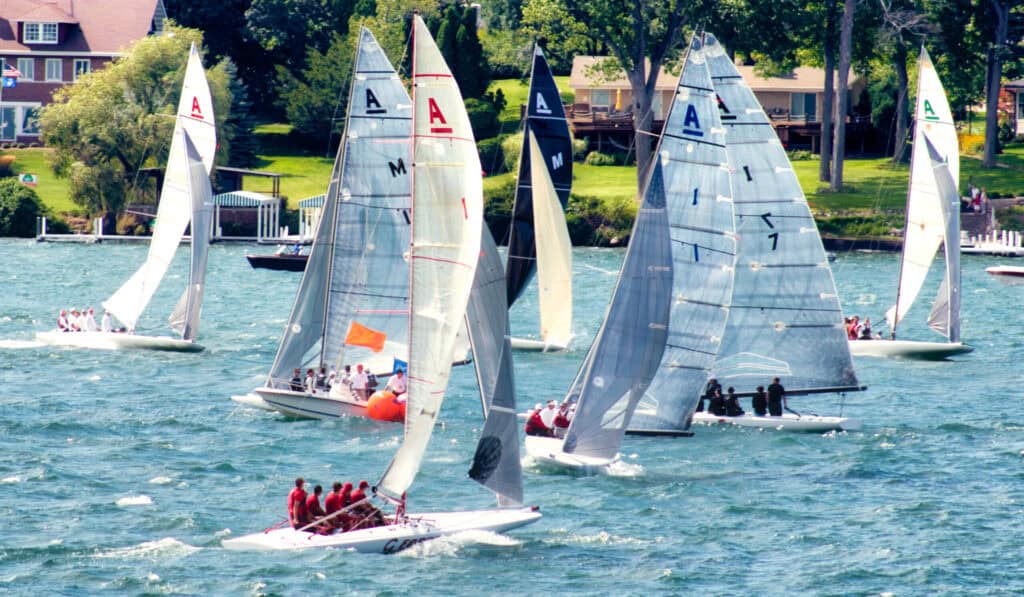 Multiple sailboats racing on Lake Geneva during a sunny day.