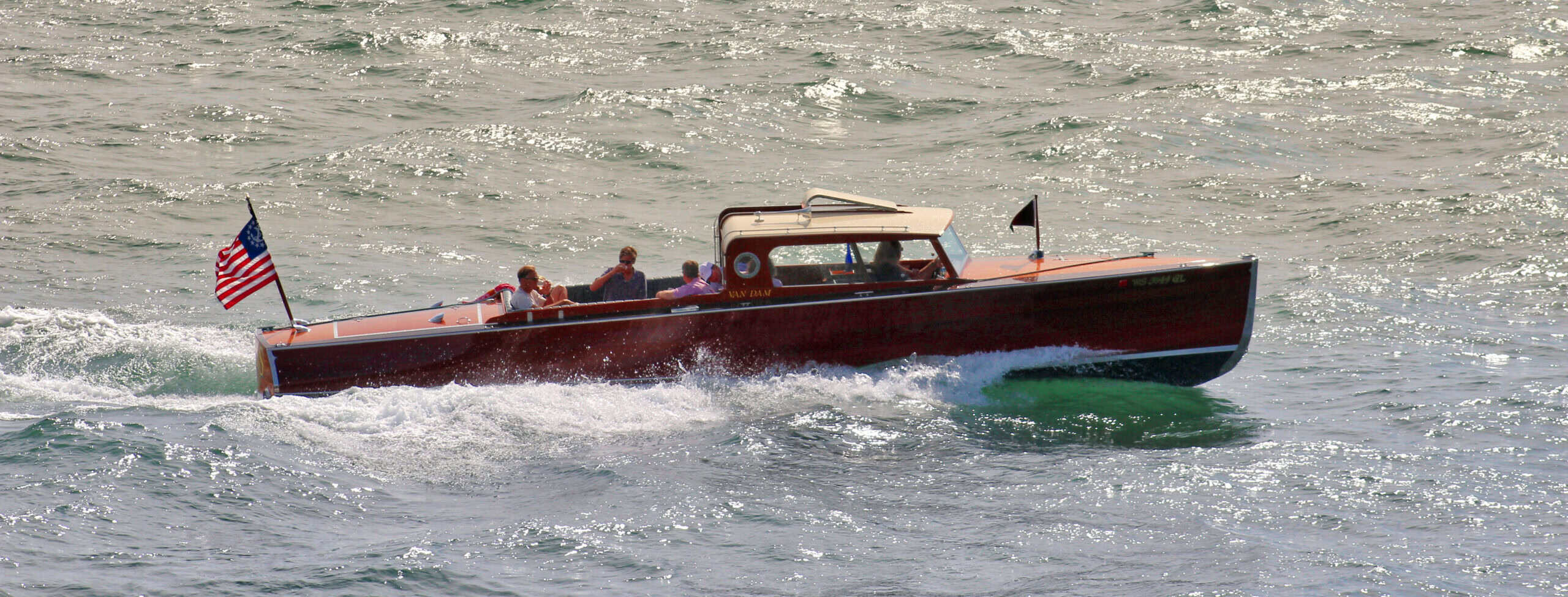 Speedboat cruising on Lake Geneva with American flag in the background.