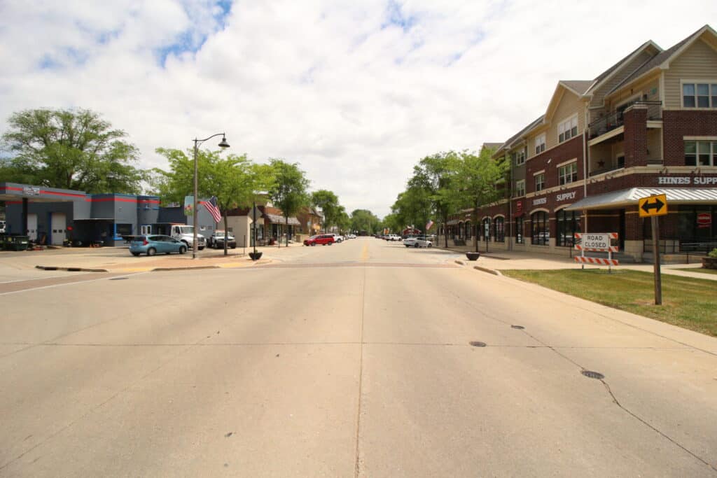 Main street in Lake Geneva with shops and trees on a sunny day.