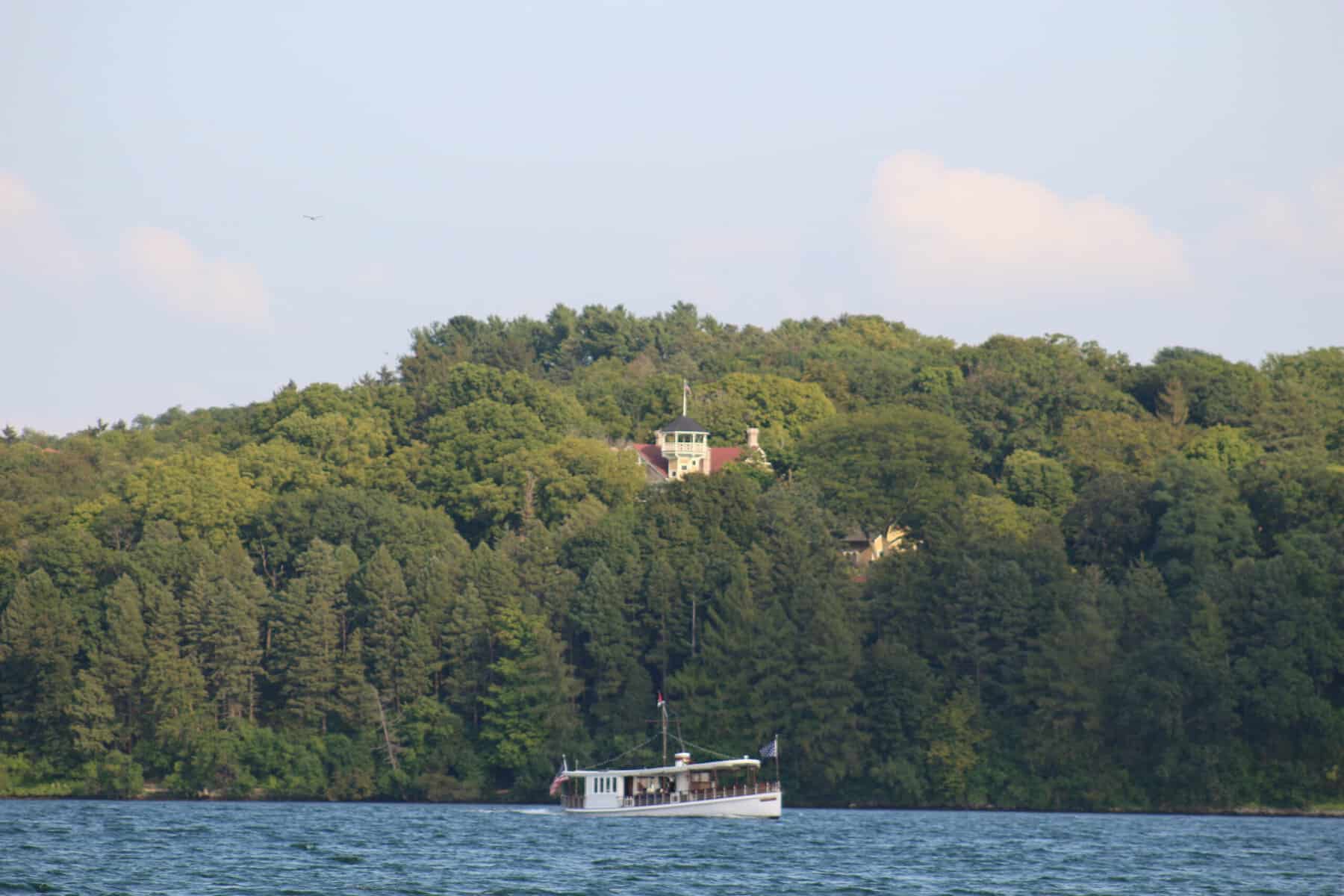 The Polaris tour boat passing below Black Point Estate, whose tower rises above the trees on the south shore of Geneva Lake