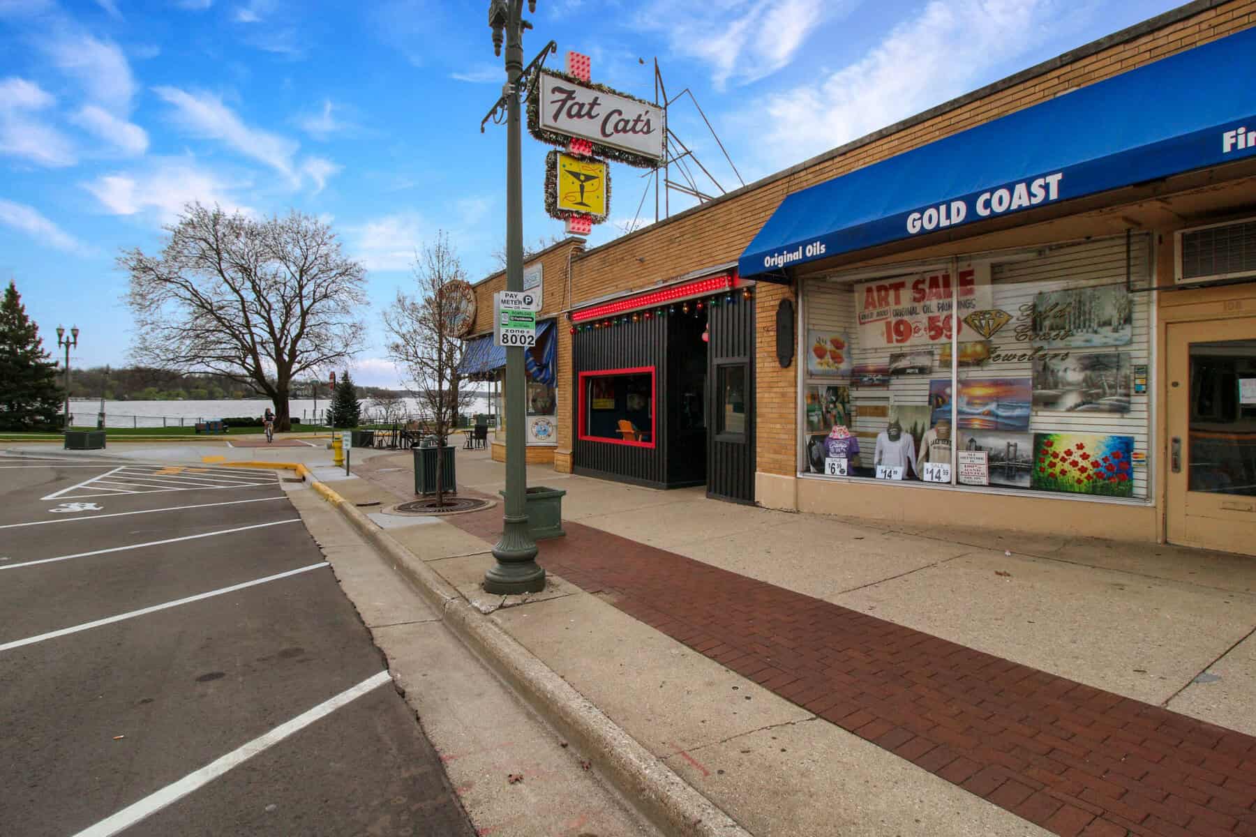 Fat Cat's neon sign on Broad Street with Geneva Lake behind