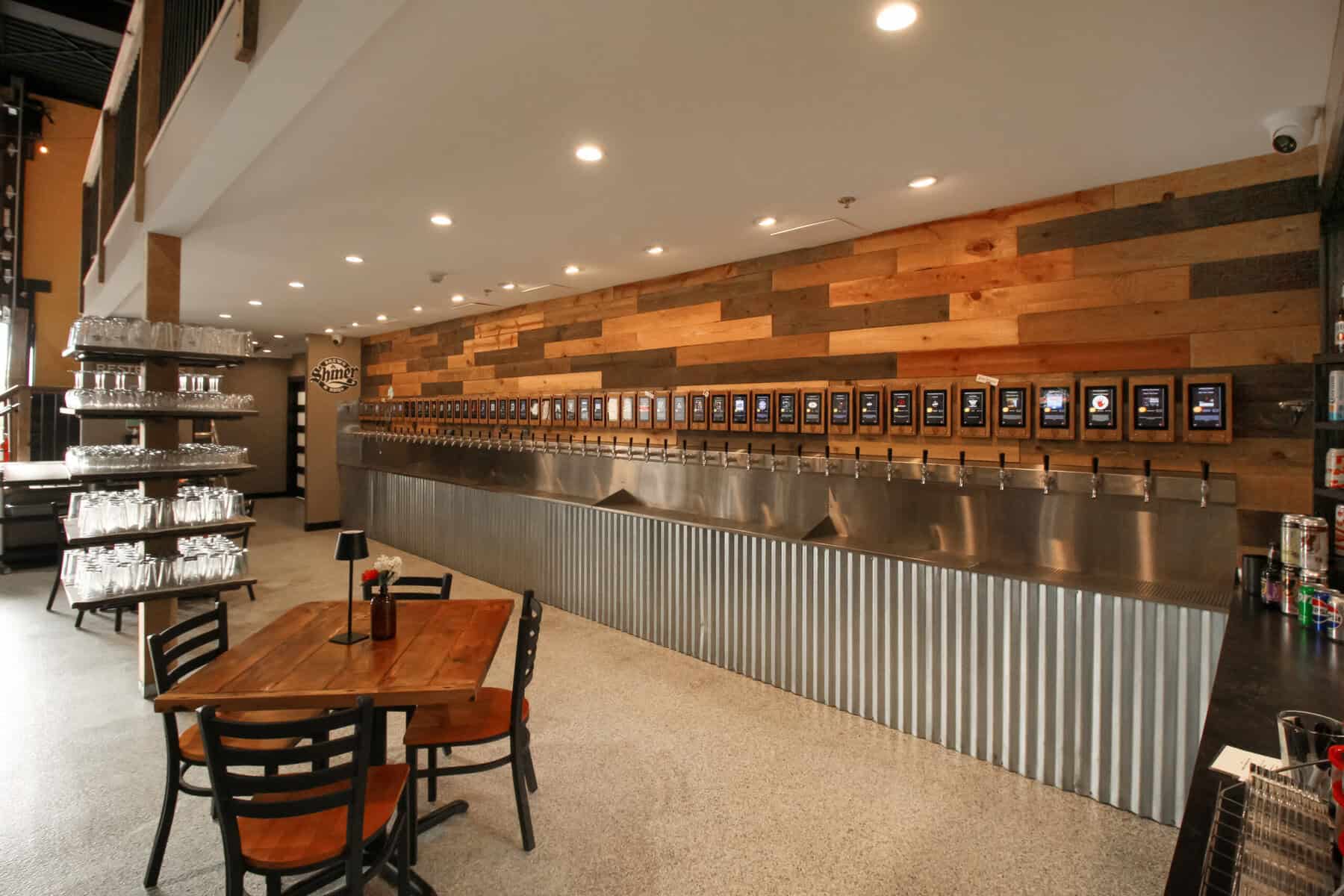 Geneva Tap House wall of self-pour beer taps with digital screens