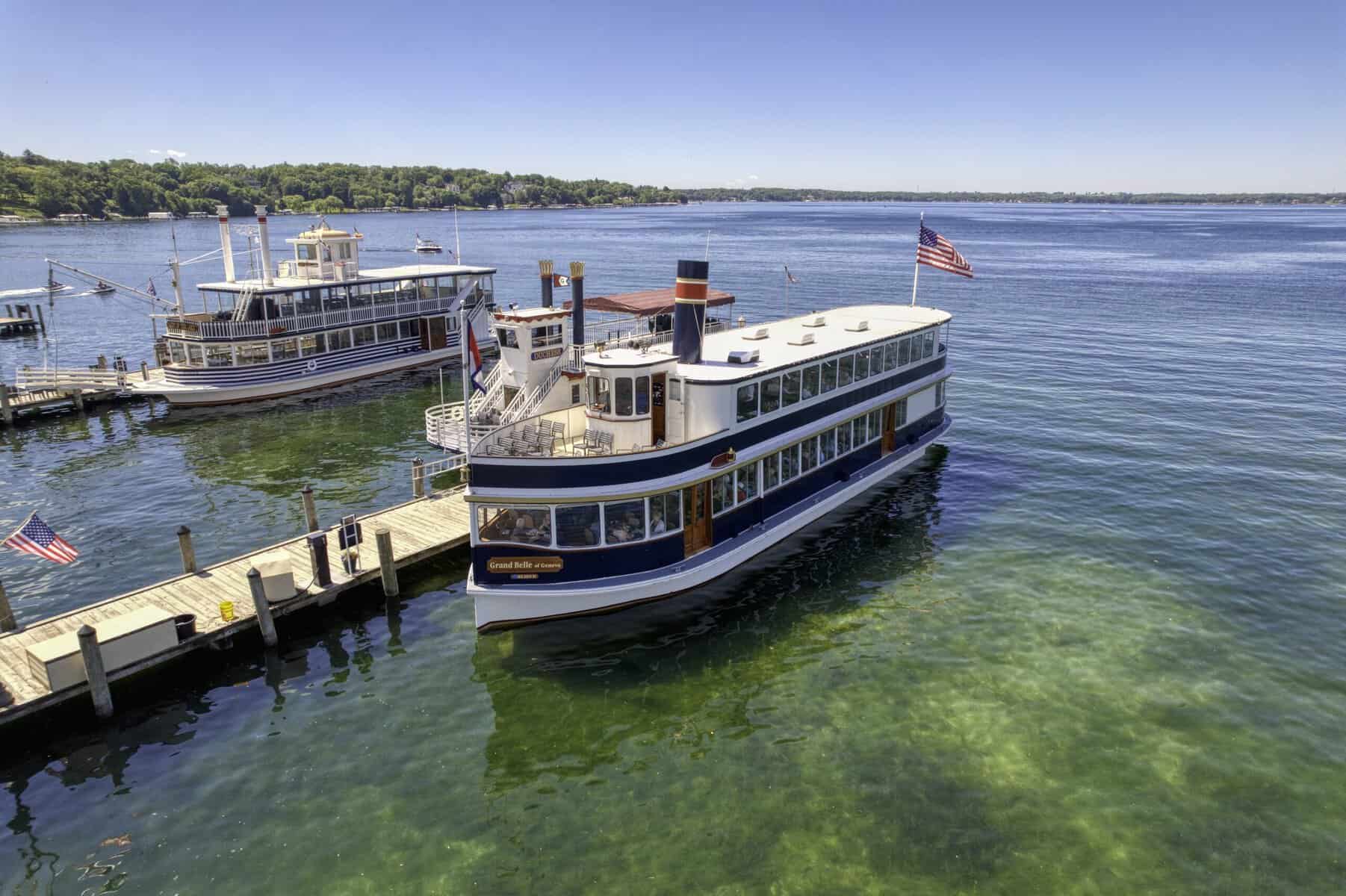 The Grand Belle of Geneva docked at the Riviera with a paddlewheeler moored behind it