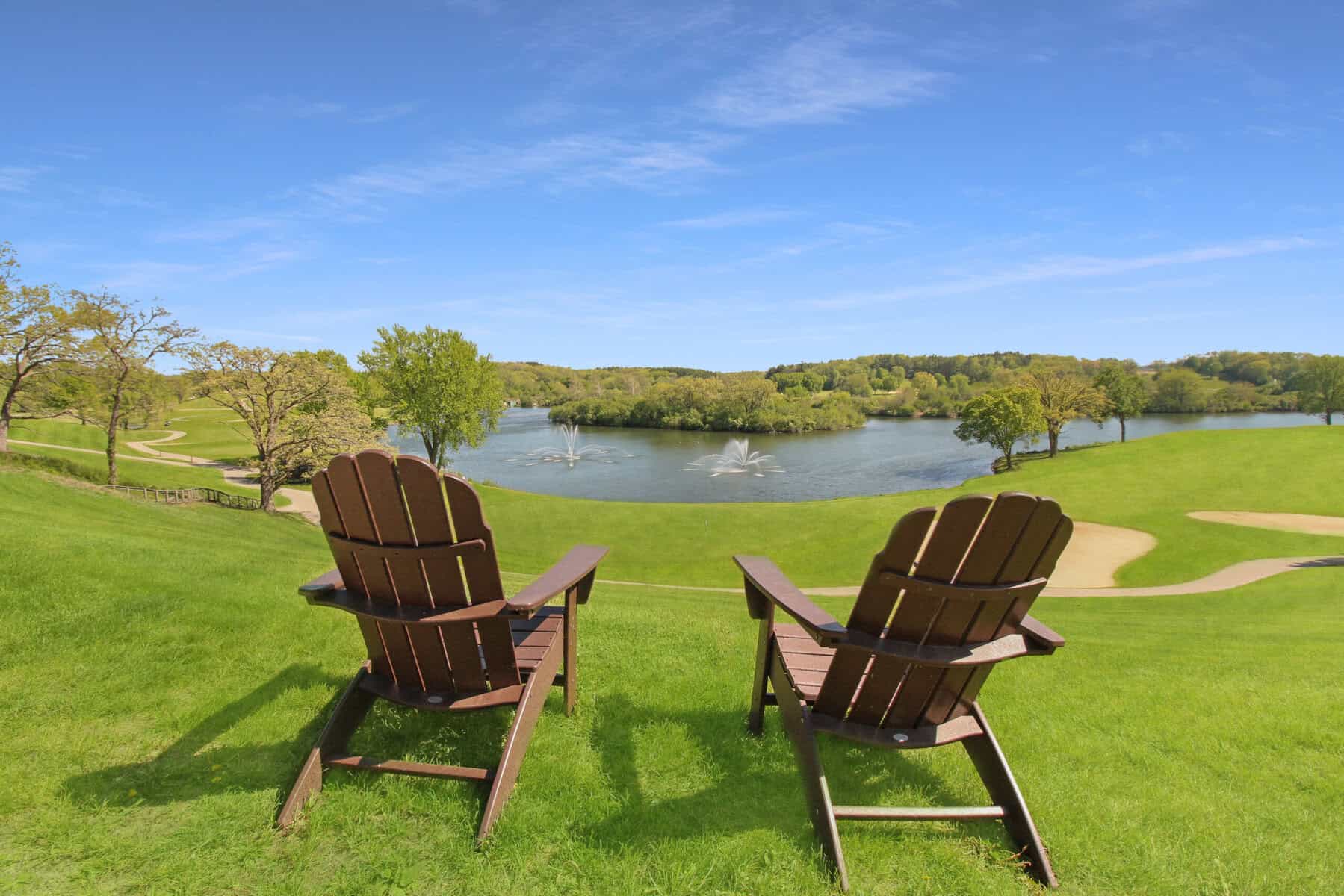 Adirondack chairs above a Grand Geneva fairway and fountain pond