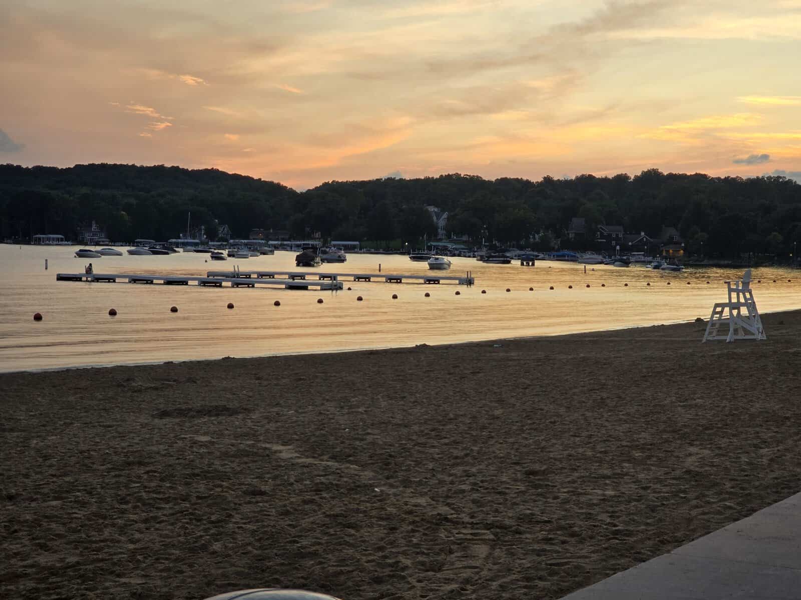 Riviera Beach at sunset with lifeguard chair, piers and moored boats