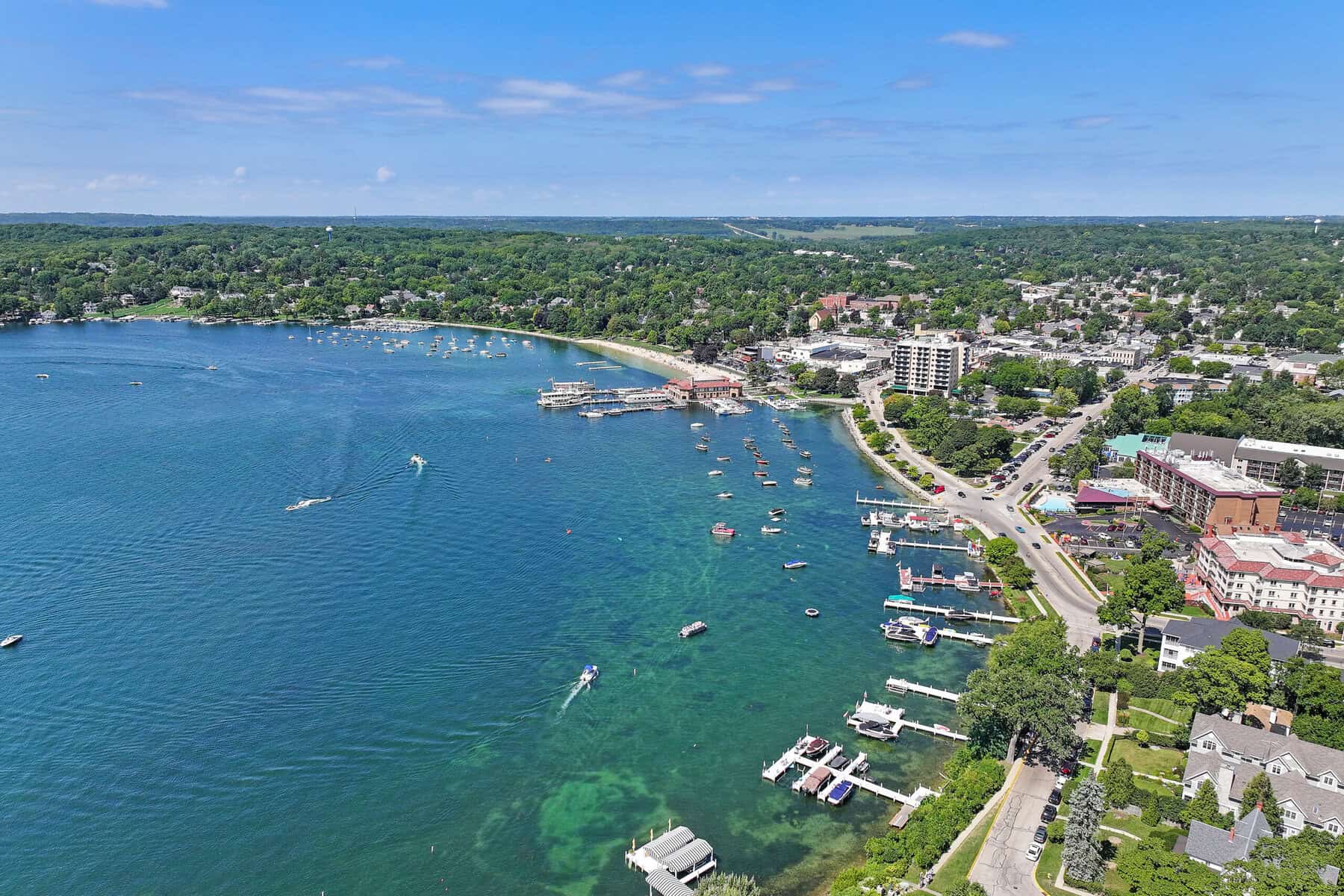 Aerial view of downtown Lake Geneva bay with rental piers along Wrigley Drive and the Riviera in the distance