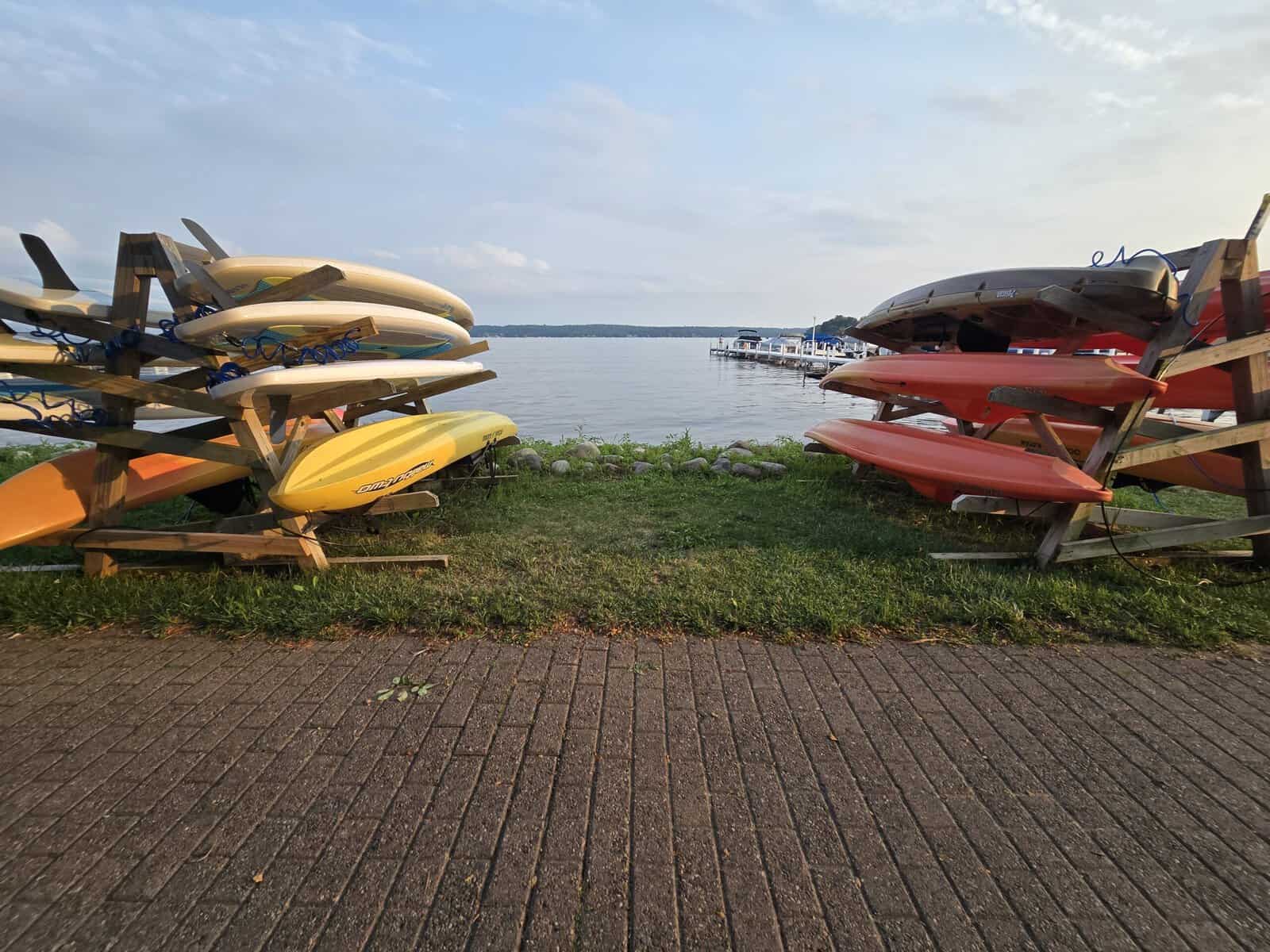 Rack of rental kayaks beside the lake and a public pier