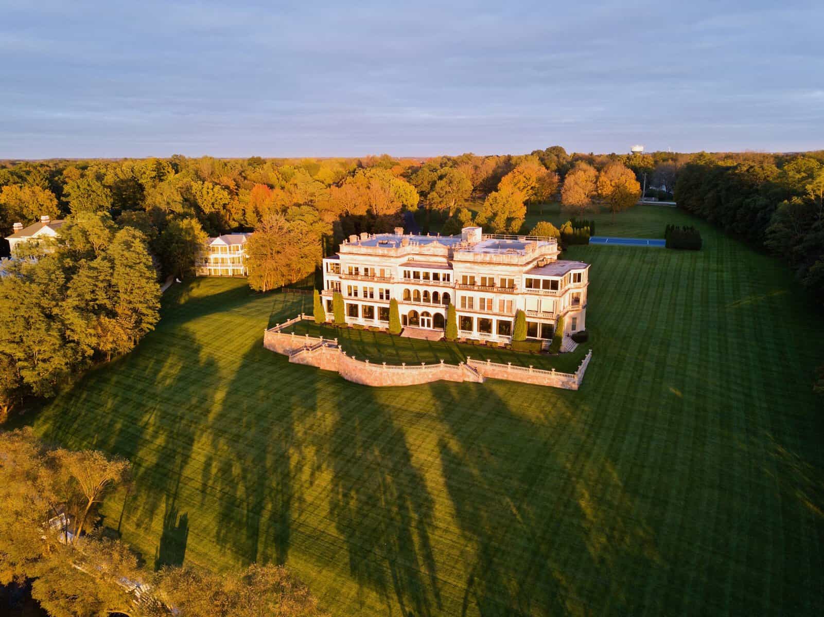 Aerial view of Stone Manor and its terraced lawn on the Geneva Lake shoreline at sunrise in fall