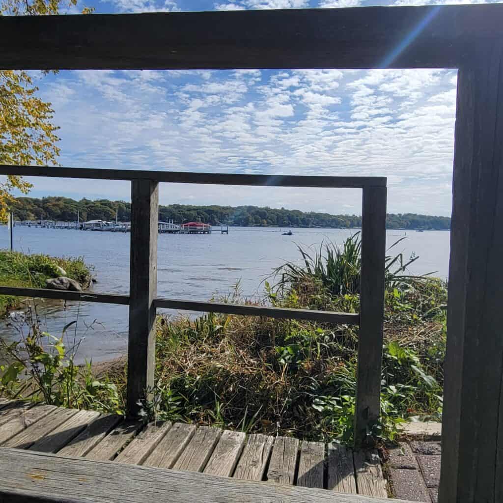 Scenic view of Lake Geneva through a wooden railing on a sunny day.