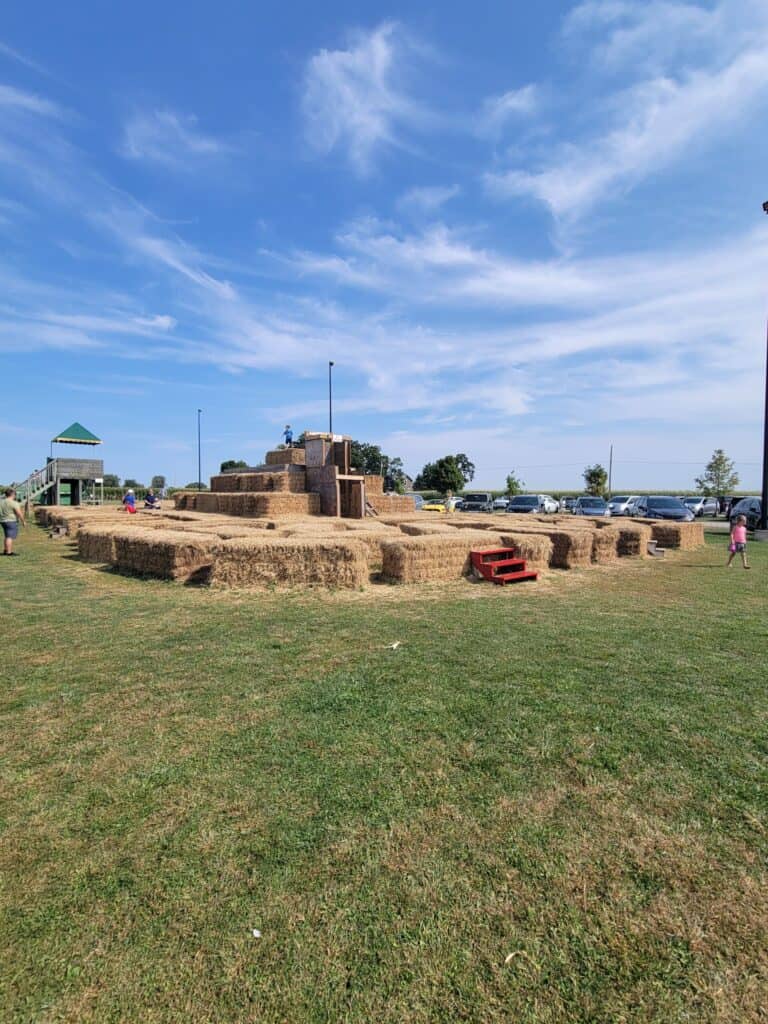 Hay bale sculpture at Lake Geneva with blue sky and clouds.