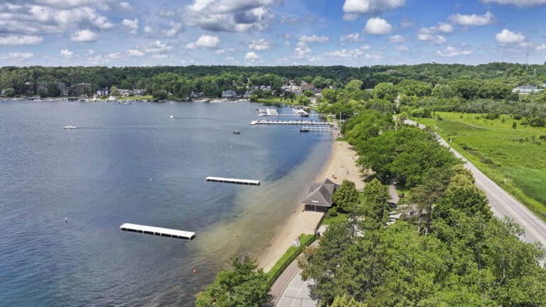 Scenic aerial view of Lake Geneva with boats and green shoreline on a sunny day.
